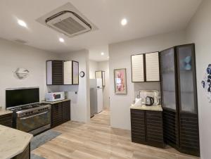 a kitchen with black cabinets and a television in it at Ain Arees in Al Madinah