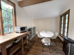 eine Küche mit einem Tisch, einer Mikrowelle und Stühlen in der Unterkunft Cottage Retreat - Historic Cottage Home w Home Gym 