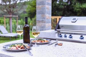 een tafel met twee borden eten en een fles wijn bij Villa Olivetum in Sečovlje