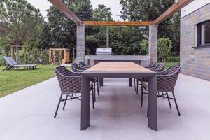 una mesa de madera y sillas en un patio en Villa Olivetum en Sečovlje