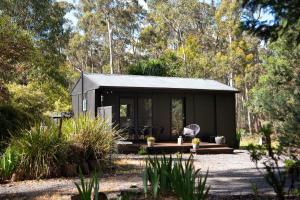 una pequeña casa negra en el bosque en Ablac Studio, en Glenlyon