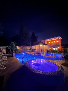 una piscina por la noche con luces azules en Hotel Boutique Family Suites, en Panguipulli