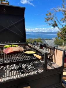 a grill with a steak and food on it at Morada del Leñador in Ushuaia