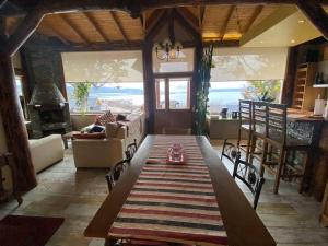 a dining room with a table and a living room with a fireplace at Morada del Leñador in Ushuaia
