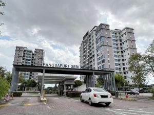 un coche blanco estacionado en un estacionamiento con edificios altos en J&R Homestay Johor Bahru near Austin Southkey CIQ Singapore, en Kangkar Teberau