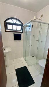 y baño con ducha acristalada y lavamanos. en CASA VERDE en Ubatuba