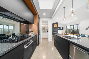 a kitchen with black cabinets and a counter top at CatchN'Relax Taupo in Taupo