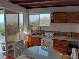 een keuken met een tafel en een tafel en stoelen bij Casa Las Mantas in Santa Marianita