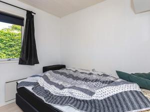 Un dormitorio con una cama con una manta. en Holiday home Roslev VI, en Roslev