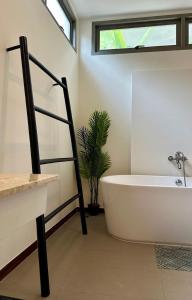 a bathroom with a white tub and a plant at 3 bedroom pool at Kavilla Rawai in Rawai Beach