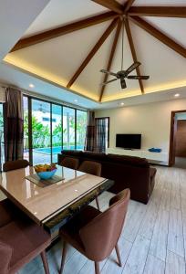 uma sala de estar com uma mesa e um sofá em 3 bedroom pool at Kavilla Rawai em Rawai Beach