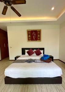 a bedroom with a large white bed with red pillows at 3 bedroom pool at Kavilla Rawai in Rawai Beach