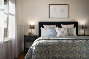 1 dormitorio con 1 cama con almohadas azules y blancas en Albion, en Daylesford