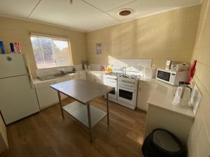 eine Küche mit weißen Geräten und einem Tisch darin in der Unterkunft Bendleby Ranges in Belton