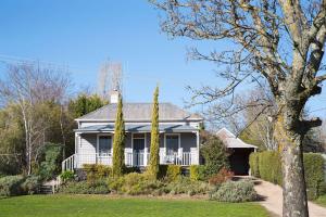 a white house with a porch and a yard at Albion in Daylesford