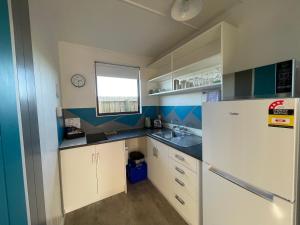 a small kitchen with a refrigerator and a sink at Alpine View Motel in Kaikoura