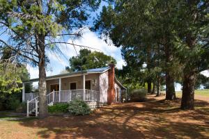 a small house with a porch and trees at All Views in Daylesford