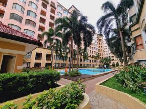 a hotel courtyard with palm trees and a swimming pool at Legarse Staycation at Montecito Residential Resort in Manila