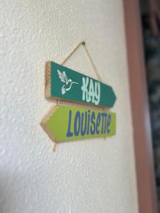Un cartello che dice "haw louiseete appeso a un muro" di Kay Louisette a Le Diamant