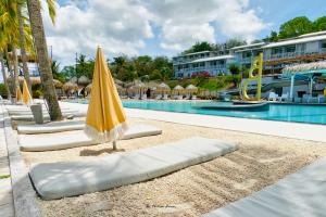 a pool with umbrellas and a swimming pool at Kay Louisette in Le Diamant