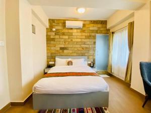 a bedroom with a bed and a brick wall at Pata Inn in Kathmandu