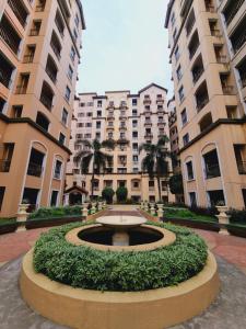 a fountain in the middle of a courtyard with tall buildings at Legarse Staycation at Montecito Residential Resort in Manila