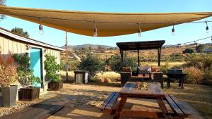 eine Terrasse mit einem Zelt, einem Tisch und einem Klavier in der Unterkunft Finca Vidandrei CASA EUCALIPTO in Valle de Guadalupe