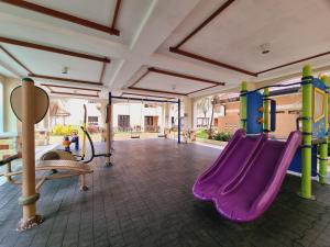 a playground with a purple slide in a room at Legarse Staycation at Montecito Residential Resort in Manila