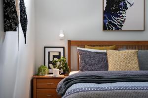 a bedroom with a blue bed and a wooden nightstand at Amaris in Daylesford