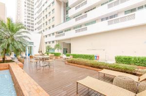 une terrasse avec des tables et des chaises ainsi qu'une piscine. dans l'établissement Studio LifeSpace Batel Curitiba, à Curitiba