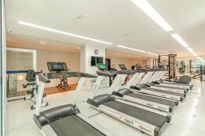 a gym with a row of treadmills and machines at Studio LifeSpace Batel Curitiba in Curitiba