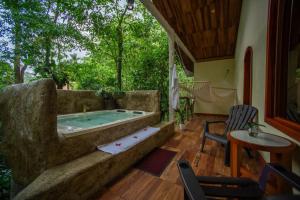 a large stone tub in a room with a table and chairs at Arenal ginger home in Fortuna