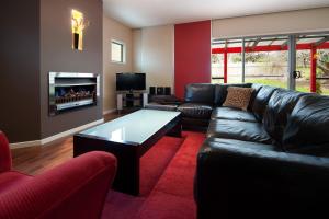 a living room with a leather couch and a coffee table at Amici in Daylesford