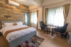 Pata Inn في كاتماندو: غرفة نوم بسرير وطاولة وكراسي