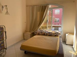 een kleine slaapkamer met een bed en een raam bij ديزرت بيرل in Hurghada