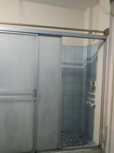 La salle de bains est pourvue d'une douche avec une porte en verre. dans l'établissement Suite Magy-Manta, à Manta
