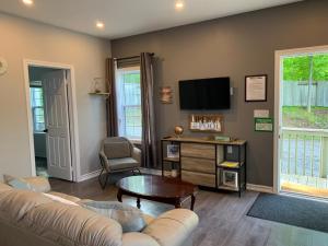 a living room with a couch and a tv at Q Estate Pool cottage in Westport