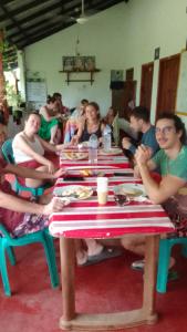 a group of people sitting at a long table at Pranu House in Nilaveli