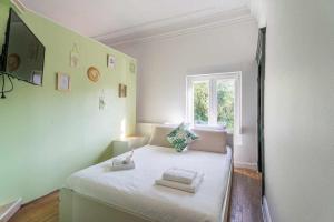 Un pequeño dormitorio con una cama blanca y una ventana en Maison spacieuse 240m² - 7chambres - 16pers', en Woippy