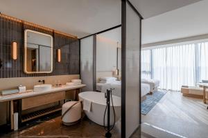 a bathroom with a tub and two beds at Nantong Marriott Hotel in Nantong