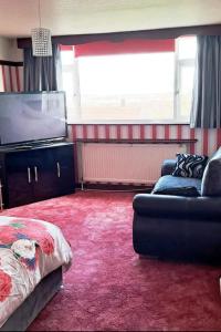 een woonkamer met een bank en een flatscreen-tv bij Home Away From Home in Nottingham