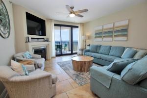 een woonkamer met een bank en stoelen en een tv bij Broadmoor 304 in Orange Beach