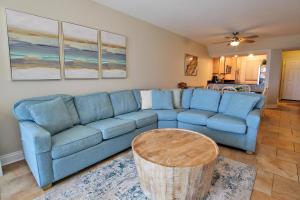 a living room with a blue couch and a table at Broadmoor 304 in Orange Beach