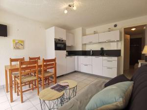 cocina y sala de estar con sofá y mesa en Appartement Carnac, 2 pièces, 4 personnes - FR-1-477-236 en Carnac