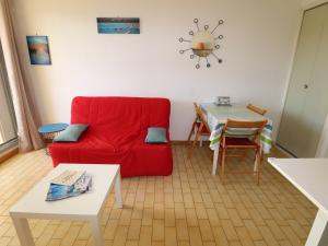 uma sala de estar com um sofá vermelho e uma mesa em Studio Le Grau-du-Roi, 1 pièce, 4 personnes - FR-1-307-244 em Le Grau-du-Roi