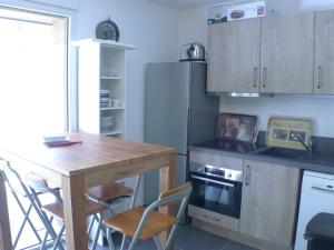 a kitchen with a wooden table and a table and chairs at Appartement Samoëns, 2 pièces, 4 personnes - FR-1-629-128 in Samoëns