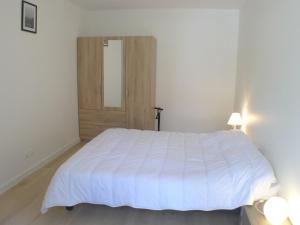 a bedroom with a white bed and a wooden door at Appartement Samoëns, 2 pièces, 4 personnes - FR-1-629-128 in Samoëns