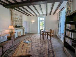 a living room with a couch and a table at Gîte familial avec piscine couverte, jardin privé, proche d'Aubeterre-sur-Dronne - FR-1-653-239 in Bellon