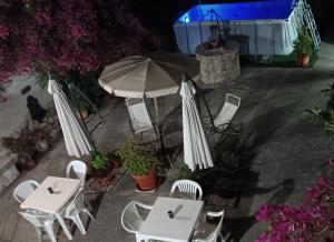 un gruppo di tavoli e sedie con ombrellone di Baglio Ferlito a Buseto Palizzolo