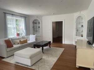 Glen Cove的住宿－Estate Getaway，客厅配有白色的沙发和桌子